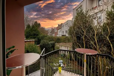 a balcony with two tables and a sunset at Tropical Room in Brussels