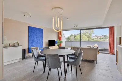 a dining room with a table and chairs at Ruim 2 slaapkamer appartement met parking nabij NAVO in Machelen