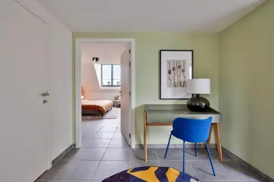 a room with a desk and a blue chair at Ruim 2 slaapkamer appartement met parking nabij NAVO in Machelen