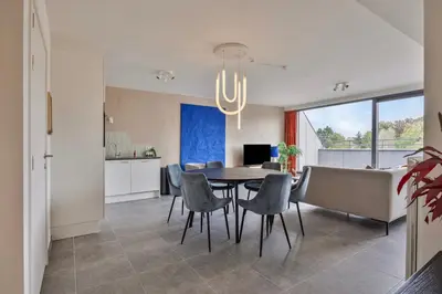 a dining room and kitchen with a table and chairs at Ruim 2 slaapkamer appartement met parking nabij NAVO in Machelen