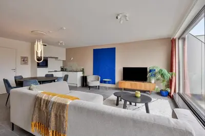 a living room with a couch and a table at Ruim 2 slaapkamer appartement met parking nabij NAVO in Machelen