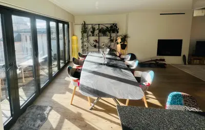 a long table in a living room with chairs at PENTHOUSE SABLON in Brussels
