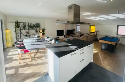 a kitchen and living room with a table and a dining room at PENTHOUSE SABLON in Brussels