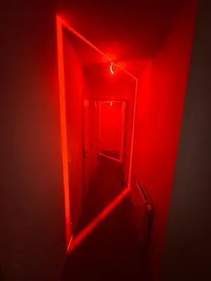 a red corridor with a door and a red light at PENTHOUSE SABLON in Brussels