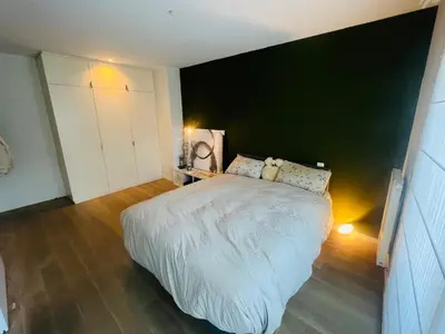 a bedroom with a white bed and a black wall at PENTHOUSE SABLON in Brussels