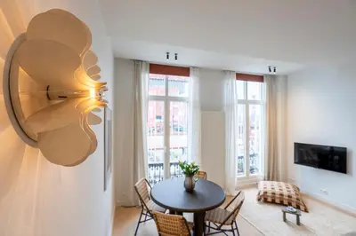 a living room with a table and chairs and windows at SHWAY - The Captain's View in Antwerp