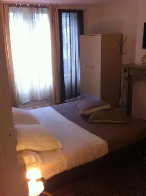 a bedroom with two beds and two windows at Hotel Residence 18 in Brussels