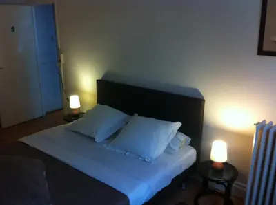 a bed with two white pillows and two lights at Hotel Residence 18 in Brussels