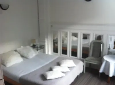 a bedroom with a large bed with pillows and a chair at Hotel Residence 18 in Brussels