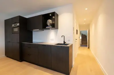 a kitchen with black cabinets and a sink at SHWAY - The First Mate's Watch in Antwerp