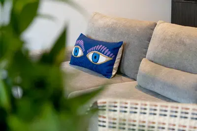 a pillow with an eye on it sitting on a couch at SHWAY - The First Mate's Watch in Antwerp
