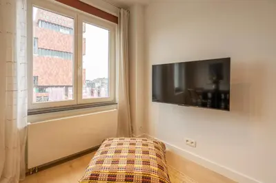 a living room with a tv and a couch and a window at SHWAY - The First Mate's Watch in Antwerp