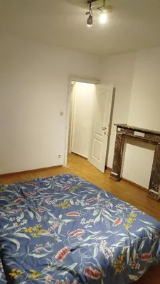 a bedroom with a blue bed with flowers on it at Charmant logement familial au cœur d'AALST Belgique in Aalst