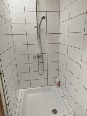 a shower in a white tiled bathroom with a sink at Charmant logement familial au cœur d'AALST Belgique in Aalst