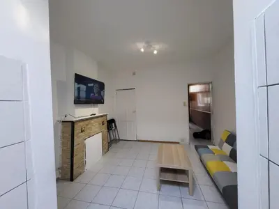 a living room with a couch and a table at Charmant logement familial au cœur d'AALST Belgique in Aalst