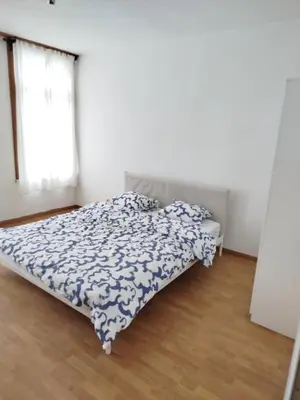 a bedroom with a bed with a blue and white comforter at Charmant logement familial au cœur d'AALST Belgique in Aalst