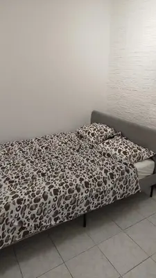 a bed with a brown and white blanket and pillows at Charmant logement familial au cœur d'AALST Belgique in Aalst
