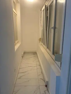 a hallway with windows and a tiled floor in a bathroom at Appartement à Bruxelles in Brussels