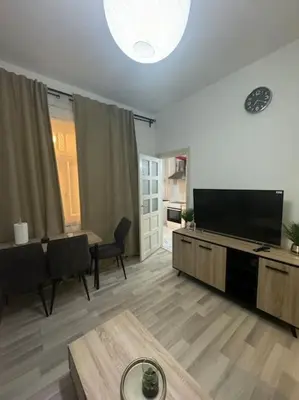 a living room with a flat screen tv and a table at Appartement à Bruxelles in Brussels