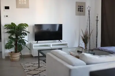 a living room with a white couch and a tv at Magnifique penthouse ERASME in Brussels