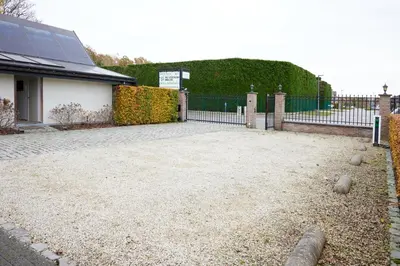 a driveway with a fence and a building at Het Molenhuisje in Brecht