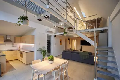 a kitchen and living room with a staircase in a loft at Het Molenhuisje in Brecht