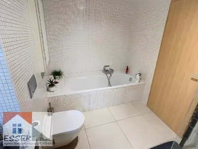 a bathroom with a white tub and a toilet at Appartement 120m2 plus terrasse in Brussels