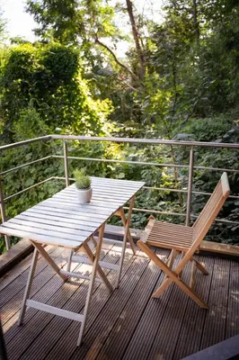 a wooden table and two chairs on a deck at Appartement 120m2 plus terrasse in Brussels