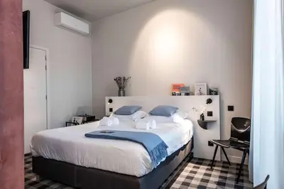 a bedroom with a large white bed with blue pillows at Studio Retreat in the Centre of Ghent in Ghent