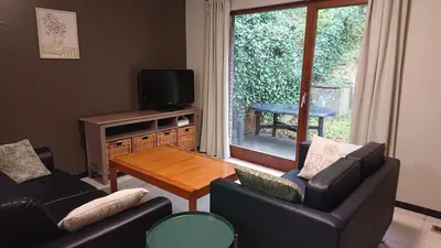 a living room with two couches and a table at Tregadata guesthouse in Overijse
