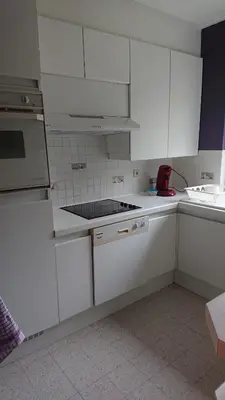 a kitchen with white cabinets and a stove top oven at Tregadata guesthouse in Overijse