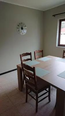 a dining room with a table and a clock on the wall at Tregadata guesthouse in Overijse