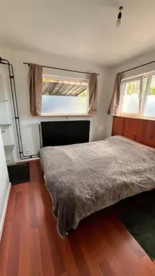 a bedroom with a bed and two windows at Casa Mellow in Ghent