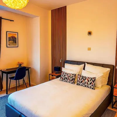 a hotel room with a bed and a desk at Brussels City Center Oasis in Brussels