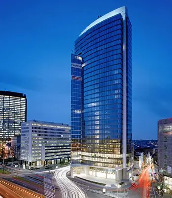 a tall glass building in a city with traffic at Brussels City Center Oasis in Brussels
