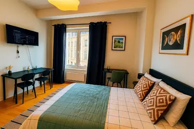 a bedroom with a bed and a desk and a window at Brussels Central City Oasis in Brussels