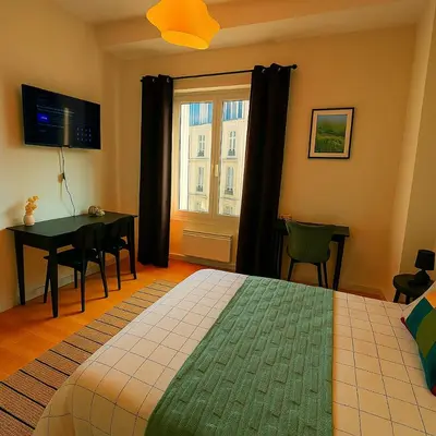 a bedroom with a bed and a table and a window at Brussels Central City Oasis in Brussels