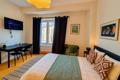 a bedroom with a bed and a desk and a window at Brussels Central City Oasis in Brussels