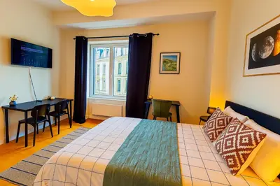 a bedroom with a bed and a desk and a window at Brussels Central City Oasis in Brussels