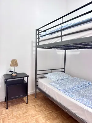 a bedroom with a bunk bed and a night stand with a lamp at Amerika Apartments in Antwerp
