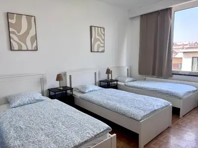 three beds in a room with a window at Amerika Apartments in Antwerp
