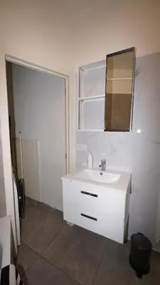 a bathroom with a white sink and a mirror at Amerika Apartments in Antwerp