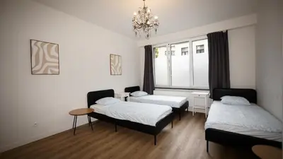 a room with two beds and a window at Amerika Apartments in Antwerp