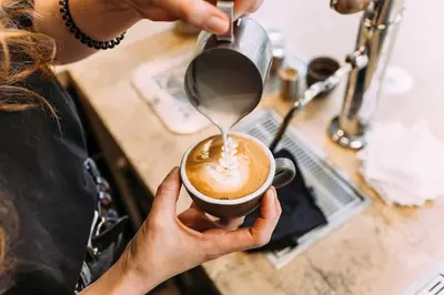 a woman is holding a cup of coffee at Studio for 2 in City of Ghent in Ghent