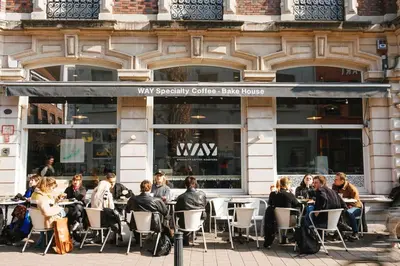 a group of people sitting at tables in front of a building at Studio for 2 in City of Ghent in Ghent