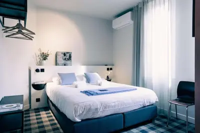 a bedroom with a large bed and a chair at Excellent Studio for Two in Central Ghent in Ghent