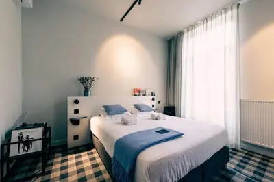 a bedroom with a large white bed with blue sheets at Charming Studio Retreat for Two in Central Ghent in Ghent