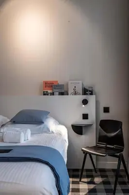 a bedroom with a bed and a black chair at Charming Studio Retreat for Two in Central Ghent in Ghent