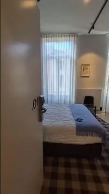 a bedroom with a bed and a window and a door at Charming Studio Retreat for Two in Central Ghent in Ghent