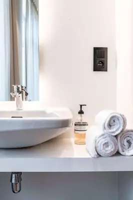 a bathroom with a sink and towels on a counter at Charming Studio Retreat for Two in Central Ghent in Ghent
